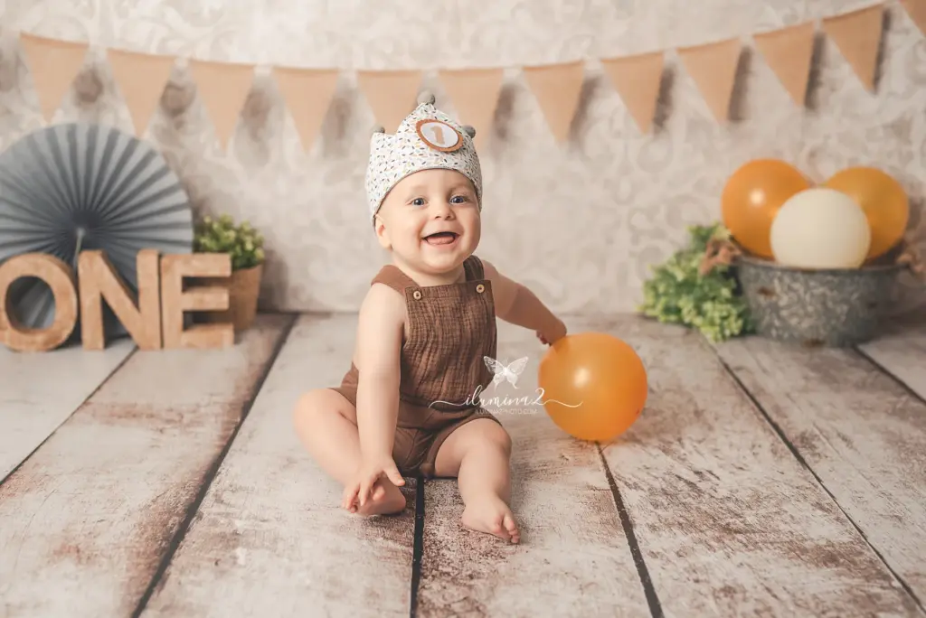 Galería 4 Bebé sonriendo mirando a cámara en un decorado de primer cumpleaños