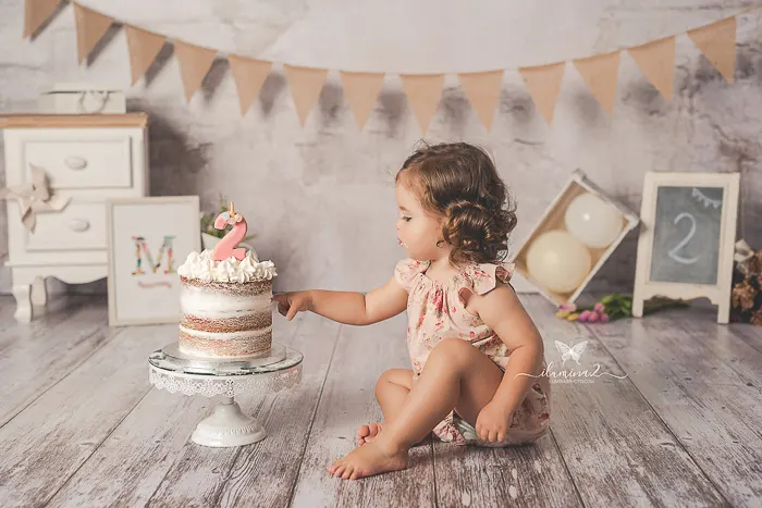¿Qué pasa si mi bebé no quiere tocar la tarta en una sesión Smash Cake? 5 Bebé tocando con calma la tarta en su sesión de primer cumpleaños