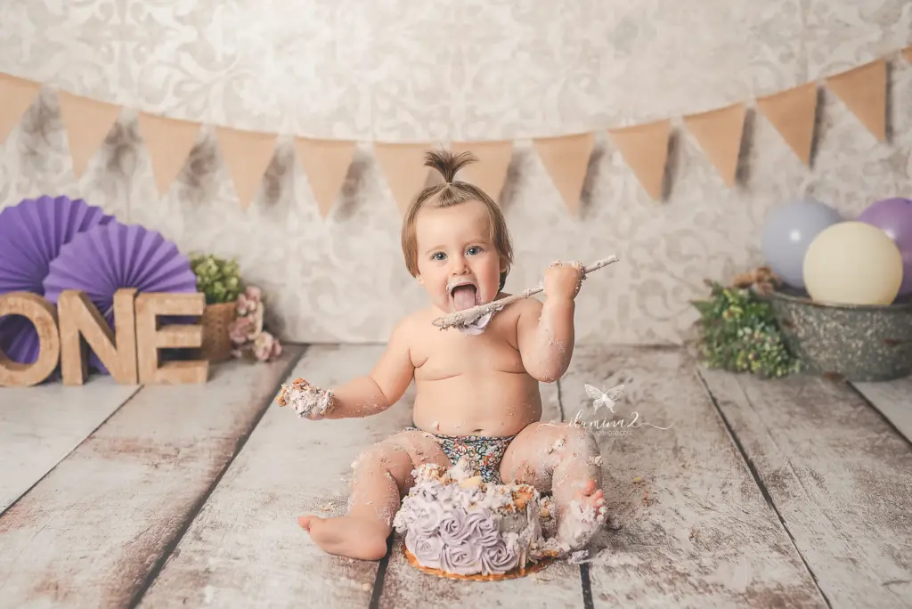 Bebé de un año jugando y comiendo pastel