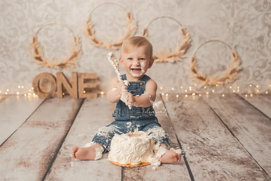 bebé de un año jugando con su pastel en su sesión de primer cumpleaños